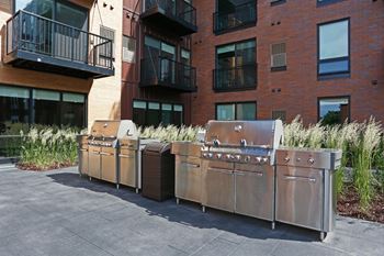 Angled view of the stainless steel grilling stations in the courtyard at Oxbo Urban Rentals.